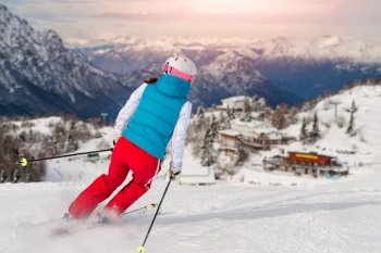 Sporty girl skiing towards the alpine hut.