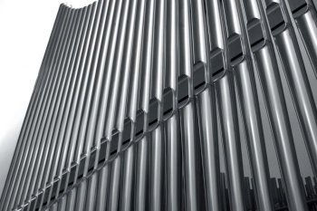 Modern steel organ pipes in a row descending. Organ pipes perspective