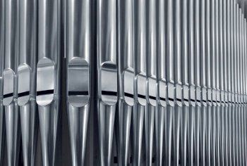 Close-up of modern steel organ pipe set horizontal. Organ pipes close