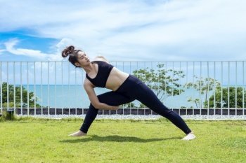 Happy Asian woman wearing black sport wear practice yoga Shoulder Opening Pose with beautiful sea view,Feeling relax and comfortable,Healthy Concept
