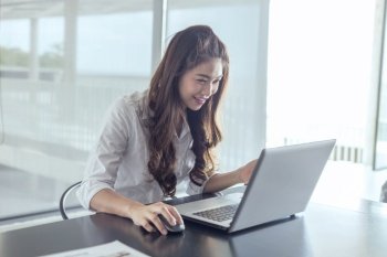 Beautiful Attractive Business Asian woman working with laptop and looking in monitor smile and have positive emotional feeling so happiness,Business Startup Concept
