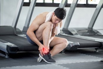 Asian man injury ankle pain after training running workout in gym feeling so pain,Healthcare Concept