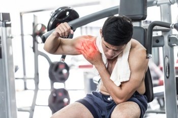 Asian man have injury muscle joint between shoulder and arm pain after workout in gym,Healthcare concept