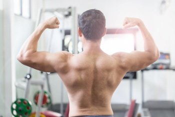 Back of view Asian men doing bodybuilder Rear Double Biceps pose in gym so strong and powerful,Bodybuilder Concept