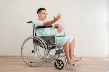 Young Man Sitting In Wheelchair At Hospital 