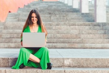 woman sitting on stairs working with a laptop