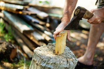 Man with an ax chops firewood. Man is chopping wood with vintage axe