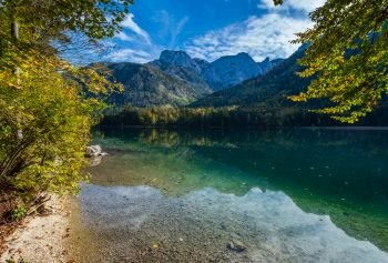 Sunny idyllic colorful autumn alpine view. Peaceful mountain lake with clear transparent water and reflections. Langbathseen lake, Upper Austria.