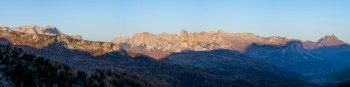 Early morning autumn alpine Dolomites mountain scene. Peaceful panoramic view from Valparola Pass, Belluno, Italy. Picturesque traveling, seasonal, and nature beauty concept scene.