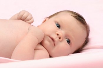 One month white baby girl in pink environment. One month baby girl