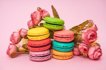 Multicolored macaroons on pink background. Sweet and colourful french macaroons