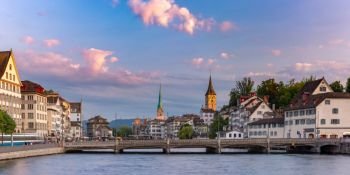 Panoramic view of famous Fraumunster and Church of St Peter and river Limmat at sunrise in Old Town of Zurich, the largest city in Switzerland. Zurich, the largest city in Switzerland