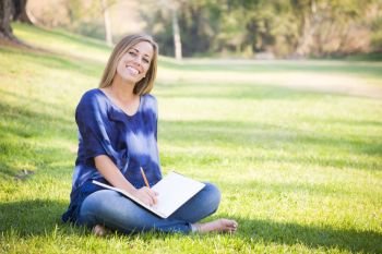 Portrait of a Beautiful Young Woman With Book Outdoors at the Park.