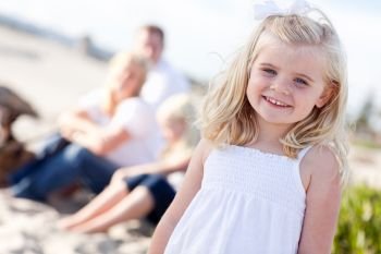 Adorable Little Blonde Girl Having Fun At the Beach with Her Family.
