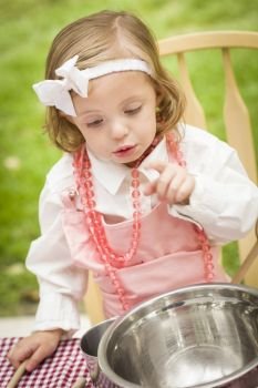 Happy Adorable Little Girl Playing Chef Cooking in Her Pink Outfit.