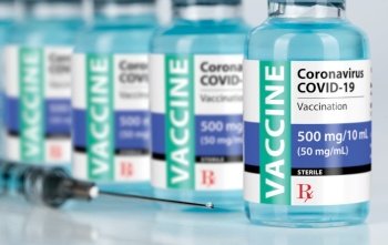 Coronavirus COVID-19 Vaccine Vials and Syringe On Reflective Surface.