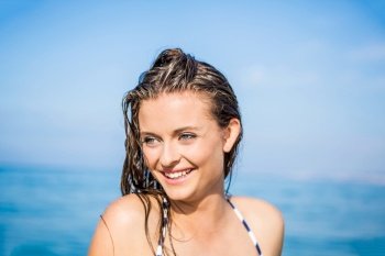 Outdoor portrait of a beautiful young woman with the ocean in the back