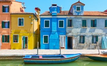 Colorful houses by canal in Burano island in Venice, Italy - Italian cityscape