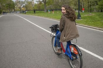 Happy woman riding a bicycle on road, Central Park, Manhattan, New York City, New York State, USA