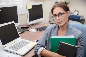 Portrait of a nice office worker, pretty female with folders in hands at work, successful business people life, young woman entrepreneur
