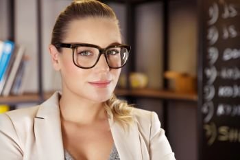 Portrait of a pretty serious woman wearing eyeglasses, young entrepreneur working in the office, successful career of a young businesswoman
