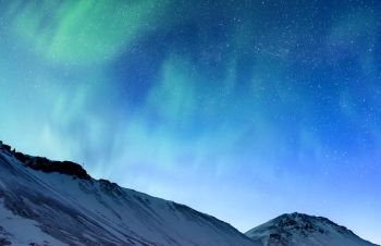 Amazing view on the Northern light and high mountains landscape covered with snow, forces of nature, Aurora Borealis, Iceland