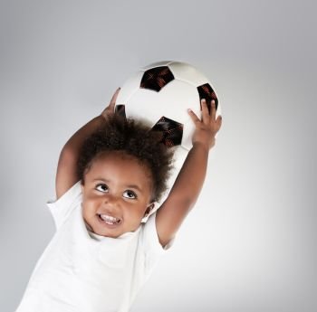 Portrait of a cute little boy with the ball, adorable small goalkeeper with soccer ball in hands over clear background, happy active childhood