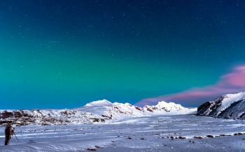 Man taking pictures of amazing view on night starry sky in Iceland, enjoying Northen Lights landscape, active winter traveling, wildlife ladscape photographer