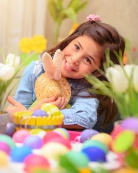
Portrait of adorable little girl with pleasure hugging her friend, soft toy Easter bunny, having fun at home in happy holiday day