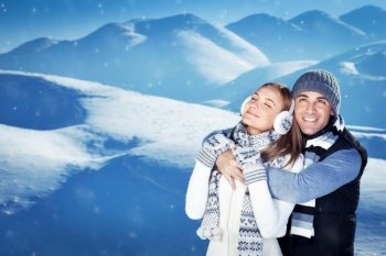 Portrait of a happy young couple having fun outdoors, handsome guy hugging his cute girlfriend, enjoying nature, spending winter holidays in the snowy mountains, romantic relationship