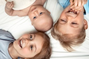 Portrait of a cheerful brother and sisters playing at home, having fun together, family love concept