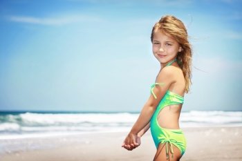 Portrait of a cute little girl on a beach, spending vacation in a summer camp on a seashore, happy healthy childhood