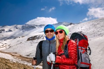 Portrait of a Nice Couple Climbing the Mountain with Trekking Poles. Enjoying Amazing View. Happy Active Winter Holidays.
