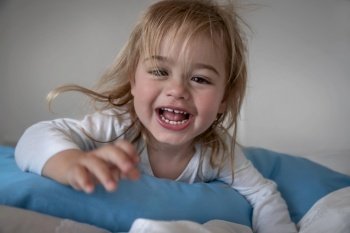 Portrait of a cute little baby boy having fun at home, enjoying happy morning time, healthy active kid, playing and relaxing on the bed