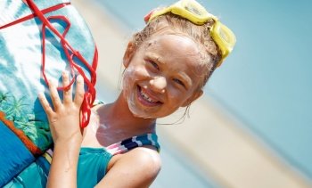 Portrait of a Nice Little Girl Wearing Water Goggles with Sunscreen on Face Holding Body Board. Spending Summer Vacation on the Sea. Happy Leisure Time on the Beach Resort. Healthy Sportive Childhood.