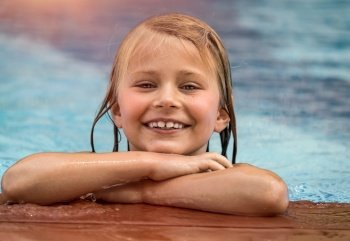 Portrait of a Cute Little Girl in the Pool. Happy Smiling Child Having Fun on the Beach Resort in Sunny day. Enjoying Summer Holidays.. Happy Little Girl in the Pool