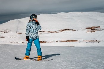 Enjoying Snowboarding. Active Woman Looking Away in High Snowy Mountains. Spending Winter Vacation on Ski Resort. Happy Sportive Lifestyle.. Winter Vacation on Ski Resort