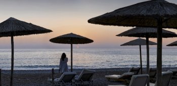 Panoramic photograph of umbrellas and sunloungers on beach in Coral Bay,Cyprus at sunset