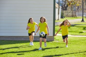 Friend girls teens playing football soccer in a park turf grass