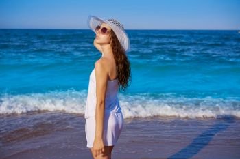 Girl with beach hat in sea shore profile view with summer white dress