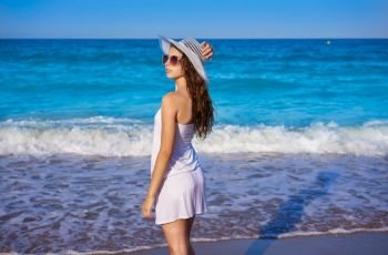 Girl with beach hat in sea shore profile view with summer white dress