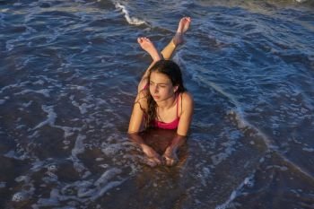Bikini girl relaxed lying on the beach sand shore water of Mediterranean sea