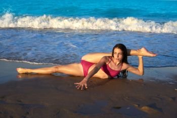 acrobatic gymnastics bikini girl in a beach blue shore at summer
