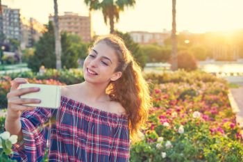 Teen girl selfie photograph in a city flowers park happy