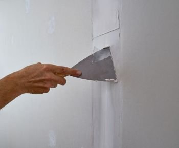 laminated plasterboard plastering join detail spatula and hand