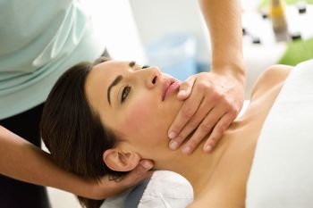 Young caucasian woman receiving a head massage in a spa center. Female patient is receiving treatment by professional therapist.