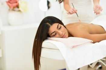 Arab woman in wellness beauty spa having aroma therapy massage with essential oil, looking relaxed Beauty and Aesthetic concepts.