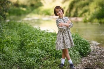 Little beautiful girl in nature stream wearing beautiful dress. Little girl in nature stream wearing beautiful dress