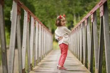 Cute little girl with four years old having fun in a rural bridge. Cute little girl having fun in a rural bridge