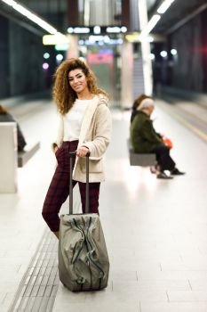 Beautiful young arabic woman waiting her train in a subway station. Arab traveler in casual clothes.. Young arabic woman waiting her train in a subway station.